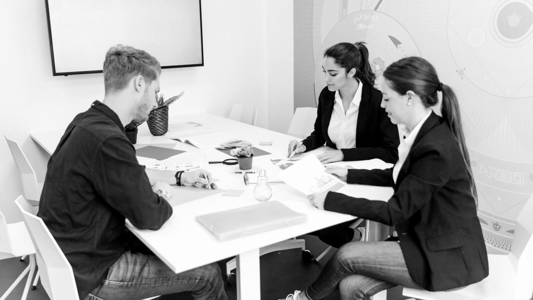 Estudiantes analizando datos financieros en pantallas modernas durante sesión de formación práctica